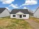 Backyard with a white house featuring a black roof, a patio, and a spacious grassy area at 1985 Meadowview Dr, Graham, NC 27253