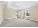 A carpeted bedroom with trey ceilings, neutral walls, and a window letting in lots of natural light at 1985 Meadowview Dr, Graham, NC 27253