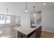 Open kitchen with quartz countertops, stainless appliances, hardwood floors and modern light fixtures at 203 Frosted Iris Lane St # 181, Garner, NC 27529