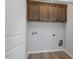 Laundry room featuring light hardwood-style flooring and cabinetry at 203 Frosted Iris Lane St # 181, Garner, NC 27529