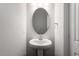 Powder room featuring a pedestal sink, decorative oval mirror, and modern lighting at 203 Frosted Iris Lane St # 181, Garner, NC 27529