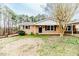 Brick home featuring a well-maintained lawn and mature trees at 2104 Live Oak Dr, Sanford, NC 27330