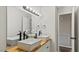 Bathroom featuring dual vessel sinks, wood countertop, large mirror, and stylish black fixtures at 2232 Miller Rd, Hillsborough, NC 27278
