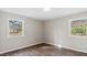 Corner bedroom with neutral paint, wood-look floors, board and batten walls and dual windows at 2232 Miller Rd, Hillsborough, NC 27278