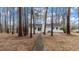 White painted brick home nestled among mature trees with a long sidewalk at 2232 Miller Rd, Hillsborough, NC 27278