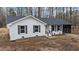 Charming white brick home featuring black shutters, dark roof, and a cozy sunroom addition at 2232 Miller Rd, Hillsborough, NC 27278
