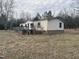 Quaint single-story home with a wooden deck set in a grassy yard surrounded by trees at 2232 Miller Rd, Hillsborough, NC 27278