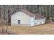 A large, detached garage with multiple bays and a neutral color scheme, set in a wooded landscape at 2232 Miller Rd, Hillsborough, NC 27278