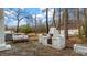 Outdoor patio featuring a brick grill, seating, and a serene wooded backdrop at 2232 Miller Rd, Hillsborough, NC 27278