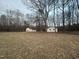 Wide view of the landscape with the house and garage across the spacious grassy yard at 2232 Miller Rd, Hillsborough, NC 27278