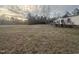 A sprawling grassy yard with an adjacent home featuring a wooden deck and forested backdrop at 2232 Miller Rd, Hillsborough, NC 27278