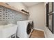 Well-organized laundry room with modern washer/dryer, stylish backsplash, and functional shelving at 2644 Catheys Creek Cir, Wendell, NC 27591