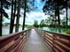 Scenic pond view showcases a wooden boardwalk extending toward a fountain and lush greenery at 2644 Catheys Creek Cir, Wendell, NC 27591