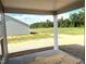 View from covered back porch overlooking spacious backyard with trees in the distance at 316 Olivia Crossing Ct # 11, Four Oaks, NC 27524