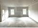 Unfinished basement ready for customization, featuring two windows and a door to the backyard at 316 Olivia Crossing Ct # 11, Four Oaks, NC 27524