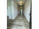 Long hallway with hardwood flooring, neutral walls, and modern lighting fixtures at 316 Olivia Crossing Ct # 11, Four Oaks, NC 27524