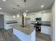 Modern kitchen with white cabinets, granite countertops, stainless steel appliances and a central island at 316 Olivia Crossing Ct # 11, Four Oaks, NC 27524