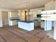Open-concept kitchen with island, white cabinets, and stylish pendant lighting at 316 Olivia Crossing Ct # 11, Four Oaks, NC 27524