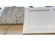 A close-up of granite countertop and white cabinet samples, showcasing texture and materials at 316 Olivia Crossing Ct # 11, Four Oaks, NC 27524