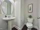 Contemporary bathroom with a pedestal sink, round mirror, modern toilet, and stylish decor at 322 Clementine Dr, Cary, NC 27519