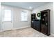 Neutral bedroom featuring carpet, bright windows, built-in dark shelving, and an outdoor-access door at 322 Clementine Dr, Cary, NC 27519