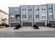 Townhome exterior featuring gray paint, private garages, covered decks, and a paved drive at 322 Clementine Dr, Cary, NC 27519