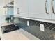 Modern kitchen featuring white cabinets, quartz countertops, and herringbone tile backsplash at 322 Clementine Dr, Cary, NC 27519