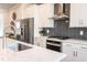 Stylish kitchen with quartz countertop, stainless steel appliances, and herringbone backsplash at 322 Clementine Dr, Cary, NC 27519