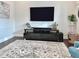 Modern living room with a sleek entertainment center and a patterned area rug over hardwood floors at 322 Clementine Dr, Cary, NC 27519