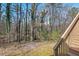 View of the wooded backyard from the wooden deck stairs at 3622 Colchester St # 13, Durham, NC 27707