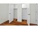 Bedroom with hardwood floors and two closets with open doors for ample storage at 3622 Colchester St # 13, Durham, NC 27707