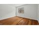Bright bedroom showcasing gleaming hardwood floors and a large window with wooded views at 3622 Colchester St # 13, Durham, NC 27707