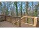 Wooden deck with railing offers a relaxing space surrounded by lush trees at 3622 Colchester St # 13, Durham, NC 27707
