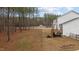 Expansive backyard with a wooden deck, firepit, wooded area and white fencing at 40 Long Needle Ct, Youngsville, NC 27596