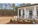 Inviting front porch features black rocking chairs, white columns, and brick accents, perfect for relaxing outdoors at 40 Long Needle Ct, Youngsville, NC 27596