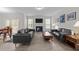 Spacious living room features a fireplace, large windows, hardwood floors, and comfortable leather sofas at 40 Long Needle Ct, Youngsville, NC 27596