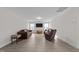 Spacious living room featuring light gray flooring, a brown couch, and a wall-mounted television at 40 Long Needle Ct, Youngsville, NC 27596