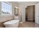Bathroom featuring a soaking tub, window, and vanity at 4009 Banks Stone Dr, Raleigh, NC 27603