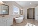 Bright bathroom with a soaking tub, double vanity, and large window at 4009 Banks Stone Dr, Raleigh, NC 27603