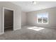 Bright bedroom features a large window, neutral carpet and walls, and a walk-in closet at 4009 Banks Stone Dr, Raleigh, NC 27603