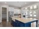 Kitchen island with stainless steel appliances and farm sink overlooking living space with fireplace at 4009 Banks Stone Dr, Raleigh, NC 27603