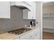Kitchen featuring white cabinets, granite countertops, stainless steel appliances, and stylish backsplash at 4009 Banks Stone Dr, Raleigh, NC 27603