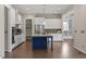 Open kitchen features an island, stainless steel appliances, granite countertops and white custom cabinets at 4009 Banks Stone Dr, Raleigh, NC 27603