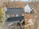 Aerial view of the house showcasing its black roof, landscaping, and proximity to surrounding trees at 4319 White Cliff Ln, Durham, NC 27712