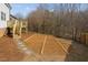 Landscaped backyard featuring a wooden deck with stairs leading to a stone pathway and mulched area at 4319 White Cliff Ln, Durham, NC 27712