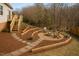 An outdoor living space with a firepit, wooden seating, and patio at 4319 White Cliff Ln, Durham, NC 27712