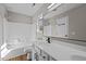 Bright bathroom with a large mirror, wood-look flooring and shower-tub combo at 4319 White Cliff Ln, Durham, NC 27712