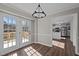 Dining room with a modern light fixture, with view to kitchen and french door access to a deck at 4319 White Cliff Ln, Durham, NC 27712