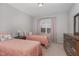 Bedroom features two twin beds with cozy floral bedspreads, along with a dark wood dresser and large window at 501 Historic Dr, Hillsborough, NC 27278