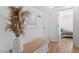 Bright hallway featuring hardwood floors, a white bench, and decorations at 506 W Gilbreath St, Graham, NC 27253